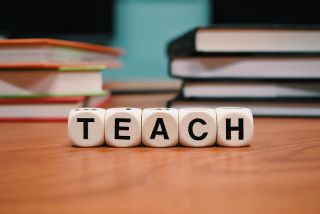 Scrabble letters spelling "teach." 