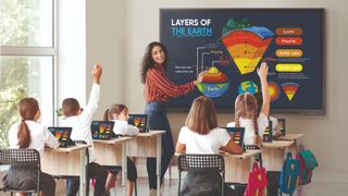 Interactive whiteboard teacher in front of class